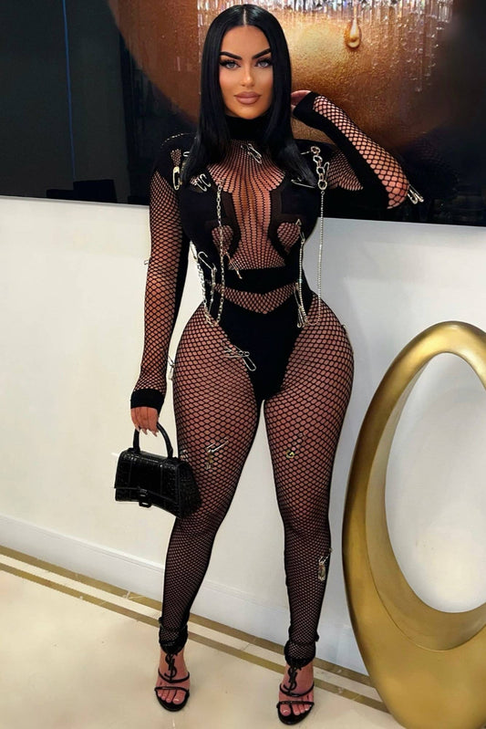 Steal the spotlight with the Chain Reaction Safety Pin Mesh Jumpsuit,a fearless blend of edgy design and seductive sophistication. Crafted from stretch fishnet mesh, this statement piece features metallic chain and safety pin accents that Demand Attention